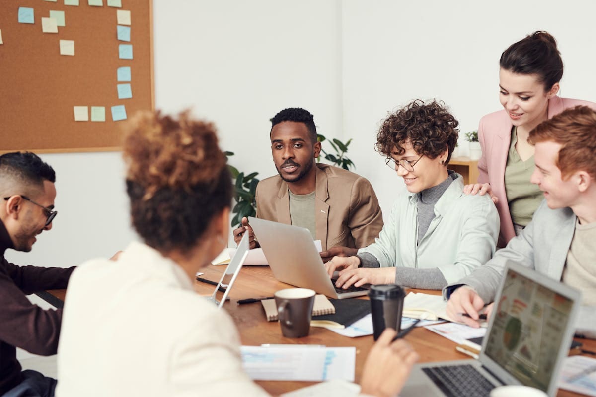 An adviser presenting to a small group seated around a meeting table