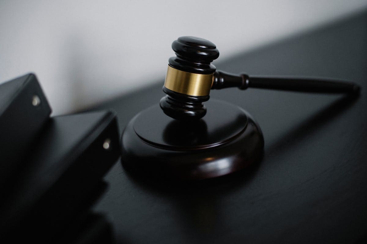 A wooden gavel resting on a dark desk